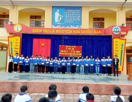 Thầy giáo Đặng Văn Hiền, Hiệu trưởng nhà trường và bác Trần Hiếu Lam, Trưởng ban đại diện Hội phụ huynh trường trao quà Tết cho các bạn học sinh